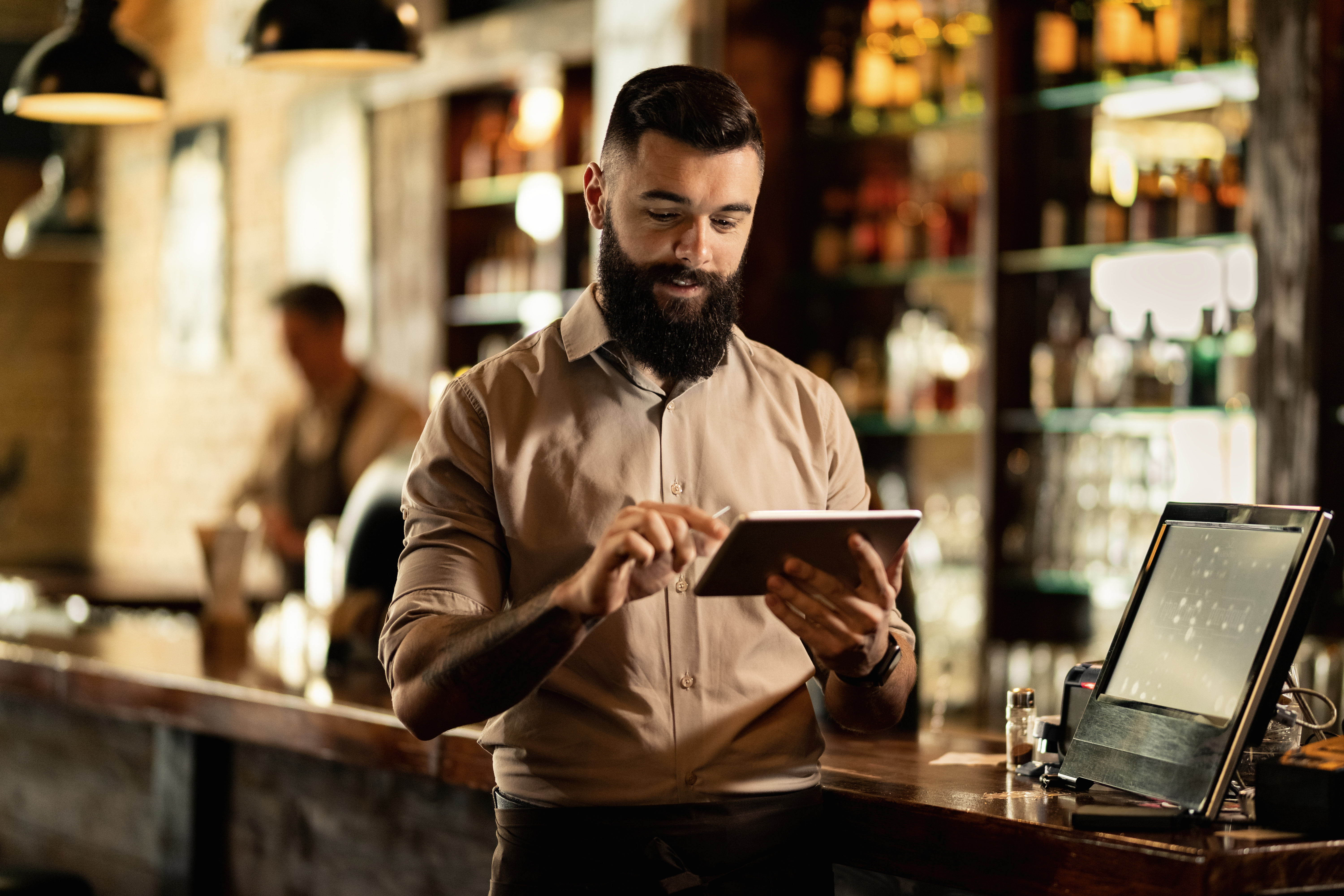 smiling-barista-using-digital-tablet-while-working-bar